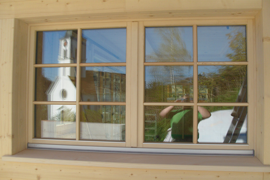 Die Holzfenster in der Ständer-Bohlen Konstruktion runden das Konzept optimal ab. , Quelle: Fensterbau Frommherz